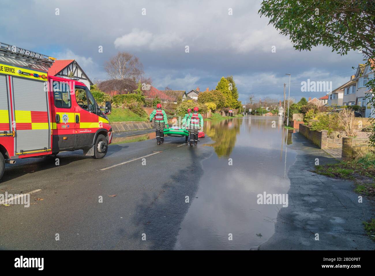 Services d'urgence transportant un bateau iflatable dans les eaux d'inondation sur la route Hinton Hereford Herefordshire Royaume-Uni. Février 2020. Banque D'Images
