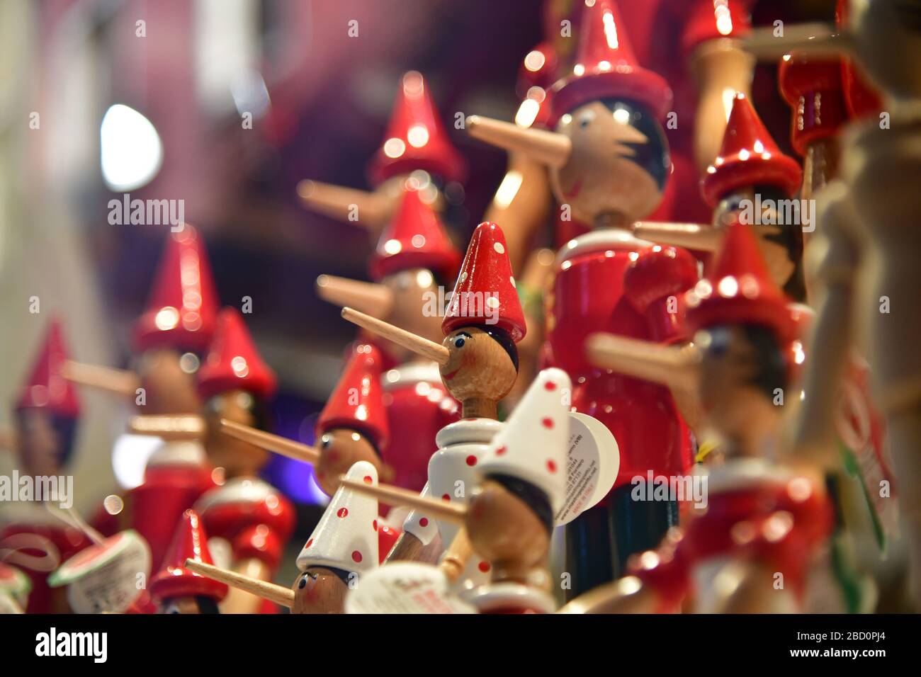 Venise, Italie-février 2020; gros plan d'un grand nombre de poupées pinocchio en magasin; une en vue et le reste dans un flou rouge-blanc Banque D'Images