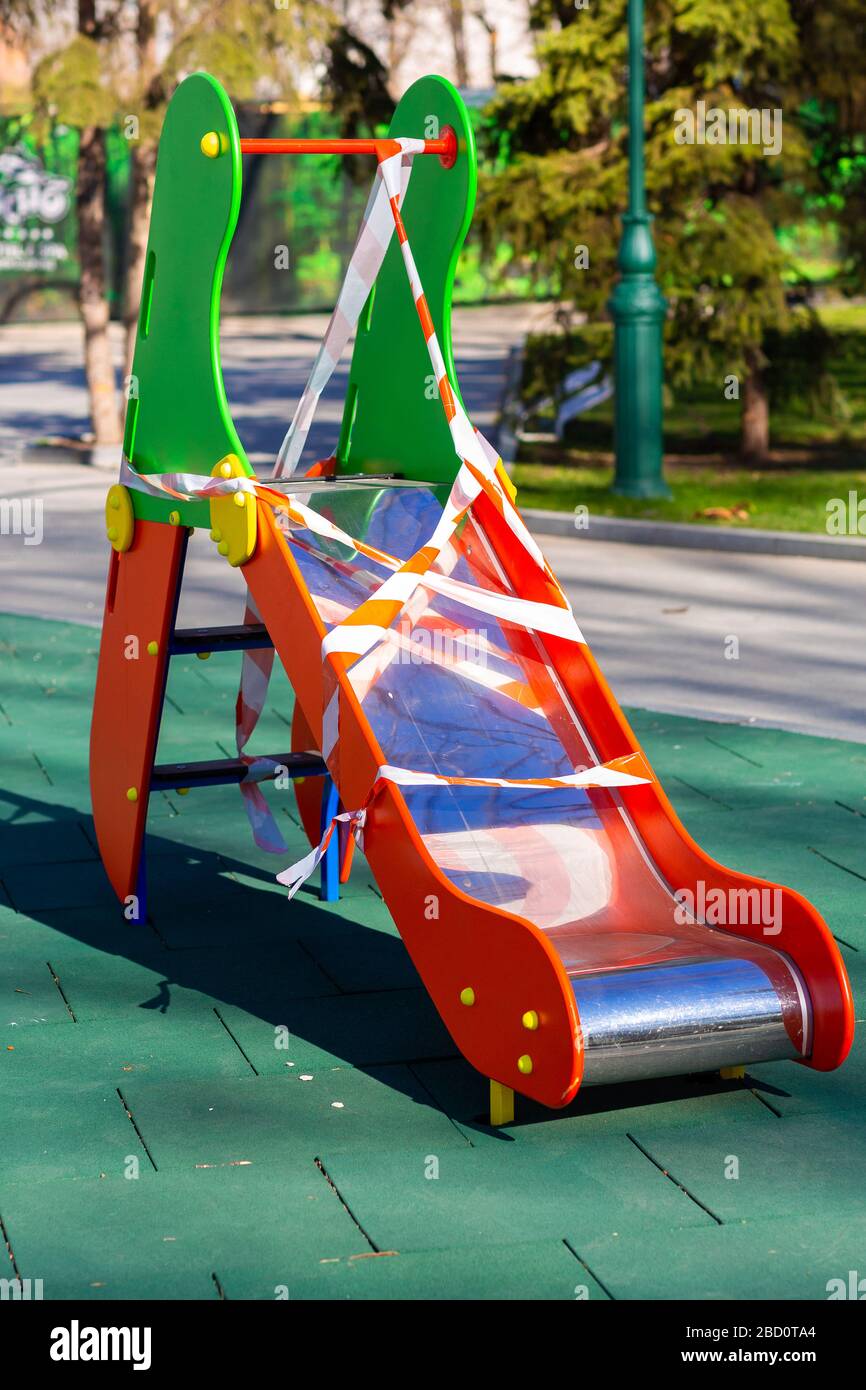 Aire de jeux pour enfants fermée et enveloppée dans un ruban de mise en garde pour la quarantaine mondiale du coronavirus.pas d'enfants sur les aires de jeux. Prévention du coronavirus Banque D'Images