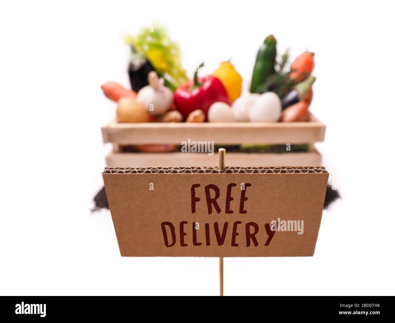 Légumes biologiques dans une boîte rustique en bois et un topsol avec étiquette carrée en carton. Étiquette de prix, étiquette cadeau, étiquette de vente, étiquette isolée sur fond blanc Banque D'Images