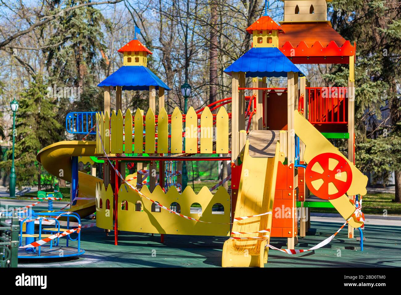Aire de jeux pour enfants fermée et enveloppée dans un ruban de mise en garde pour la quarantaine mondiale du coronavirus.pas d'enfants sur les aires de jeux. Prévention du coronavirus Banque D'Images