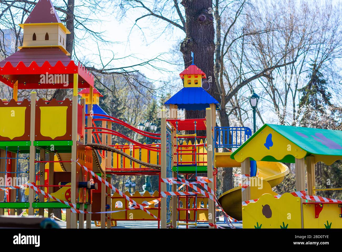 Aire de jeux pour enfants fermée et enveloppée dans un ruban de mise en garde pour la quarantaine mondiale du coronavirus.pas d'enfants sur les aires de jeux. Prévention du coronavirus Banque D'Images