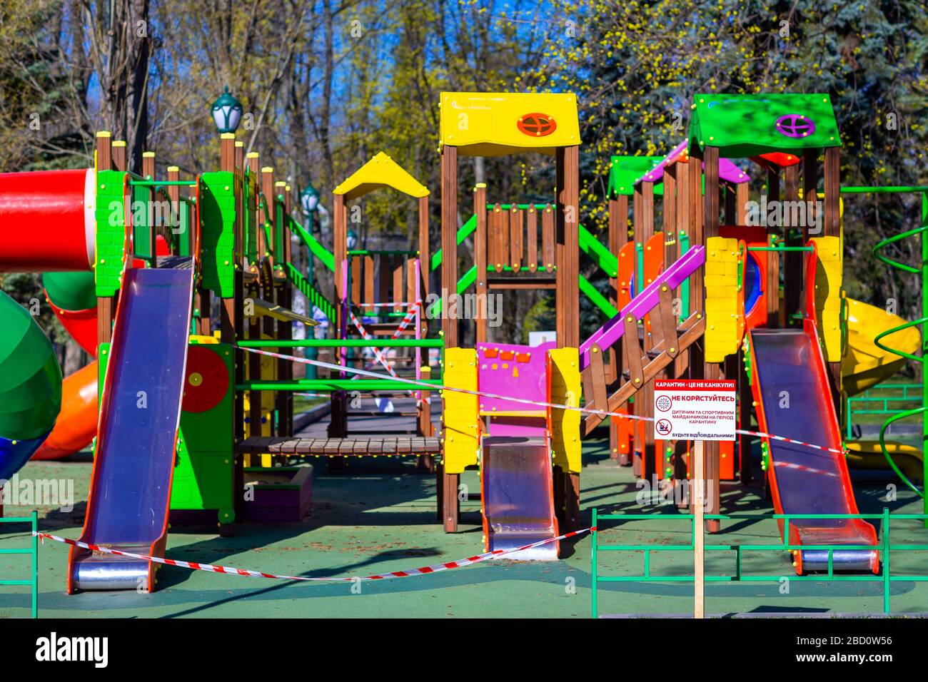Aire de jeux pour enfants fermée et enveloppée dans un ruban de mise en garde pour la quarantaine mondiale du coronavirus.pas d'enfants sur les aires de jeux. Prévention du coronavirus Banque D'Images