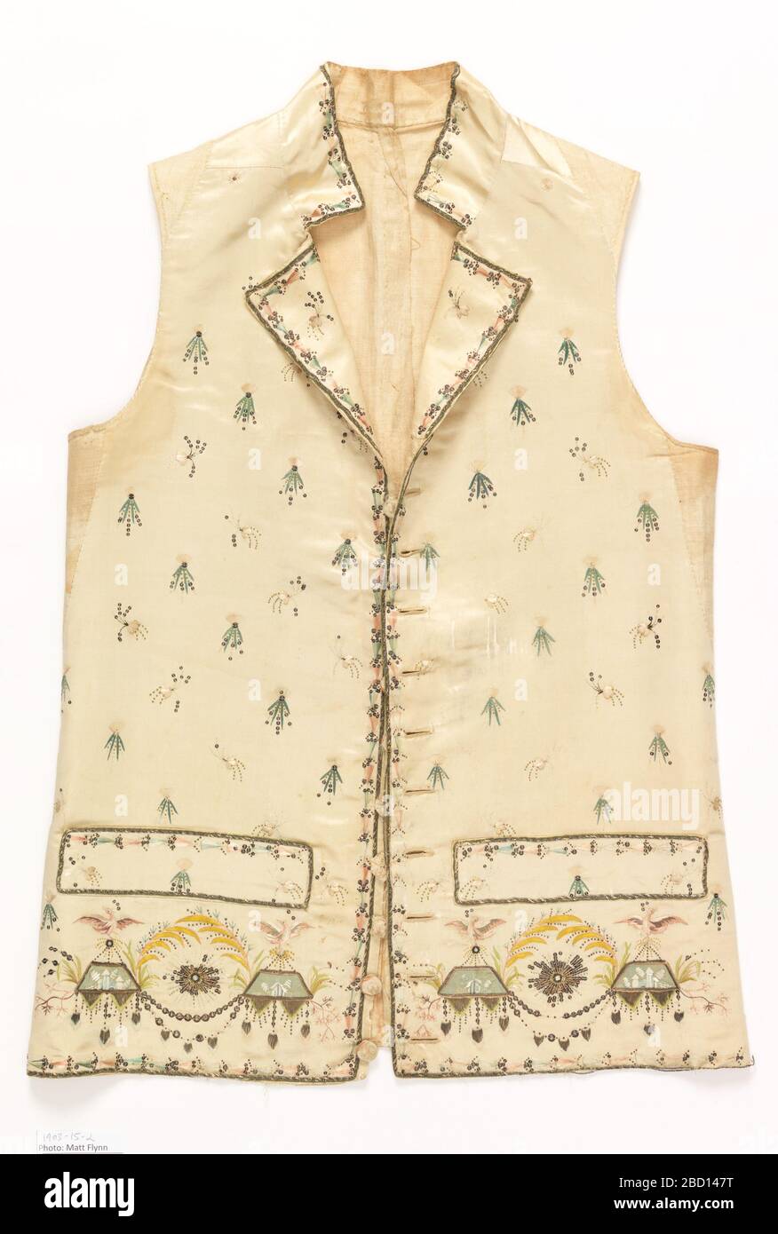 Gilet de costume. Recherche sur le gilet ProgressMen avec col sur pied, poches passepoilées et ourlet droit. Satin de soie blanc cassé brodé avec des vaporisateurs dispersés partout et ornement classique le long du bord inférieur. Dans des verts et des pinks doux avec de l'or métallique. Gilet de costume Banque D'Images