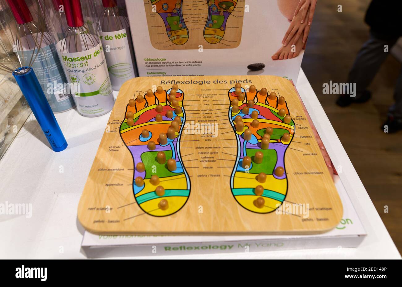 Planche en bois de réflexologie des pieds sur l'écran dans un magasin de santé et de bien-être, montrant des points de pression et des connexions à d'autres organes du corps. Paris, France Banque D'Images