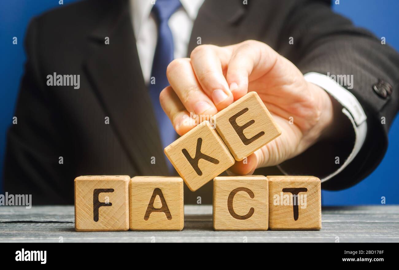 Un homme met des blocs de bois avec les mots fait et faux. Concept de nouvelles et de fausses informations. Pression jaune. Banque D'Images