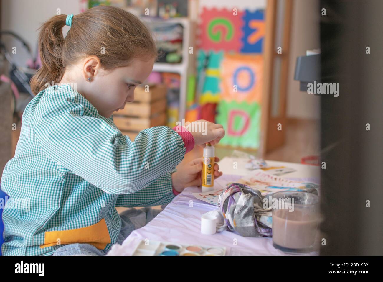 Petite peinture caucasienne d'enfant et faire quelques devoirs à auto-isolation. Concept de quarantaine et bourse d'études à domicile. Banque D'Images