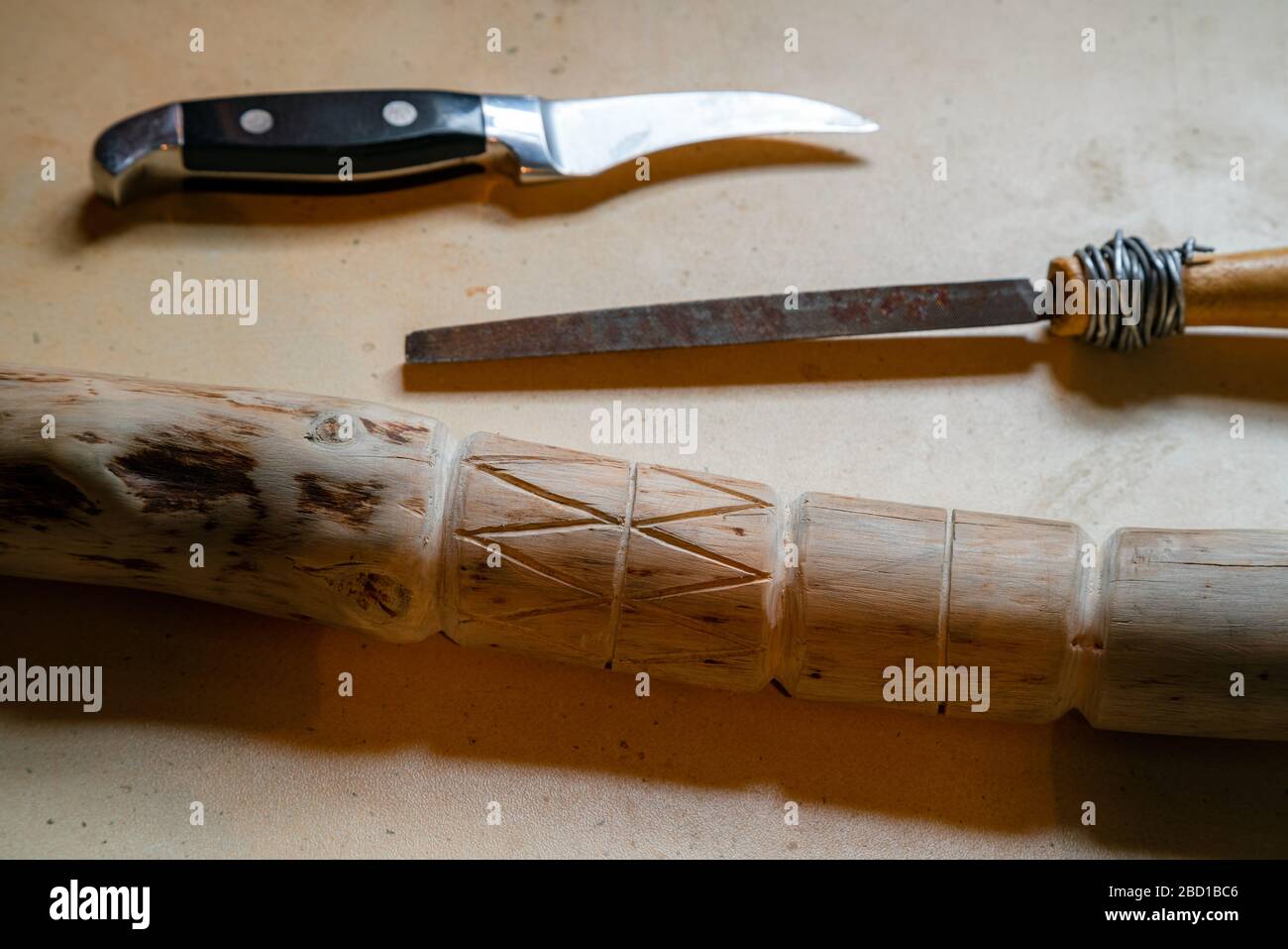 Toujours la vie du bâton de marche en bois, du couteau et de la batte sur  la table. Bâton de bois sculptant Photo Stock - Alamy