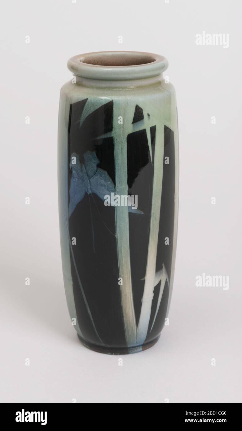 Iris. Recherche dans le corps d'argile ProgressWhite, jeté. Corps cylindrique avec col court et lèvre épaisse ; pied plat moulé. Conception composée de tiges de bambou et de feuilles dans un fond gris-vert avec deux papillons bleu pâle qui se décolent derrière des tiges. L'arrière-plan est noir. Iris Banque D'Images