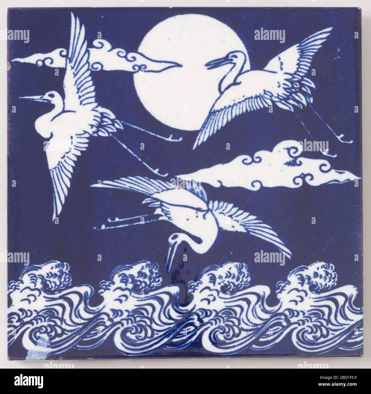 Grues japonaises sur les vagues. Recherche en faïence bleue et blanche Progressa avec une scène peinte de trois oiseaux qui survolent l'eau. Grues japonaises sur les vagues Banque D'Images