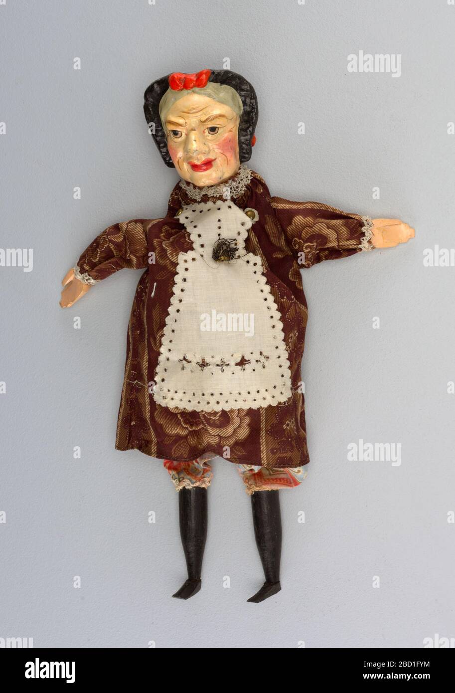 Judy. Recherche en ProgressBa peint à juste titre la tête dans le capot noir à côtes rouges. Robe à imprimé mûrier, tablier blanc et tiroirs imprimés de couleurs vives. Flexible et patins noirs. Dentelle au cou et aux genoux. Judy Banque D'Images