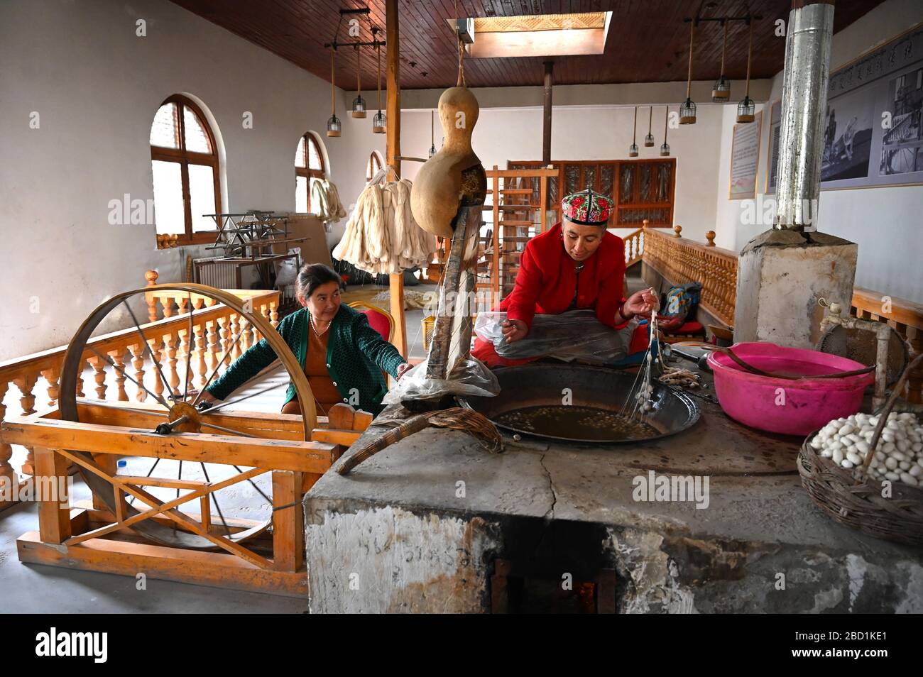 Les femmes uyghur qui firent des fils de soie de cocons dans un atelier traditionnel de soie, Jiya, Xinjiang, Chine, Asie Banque D'Images