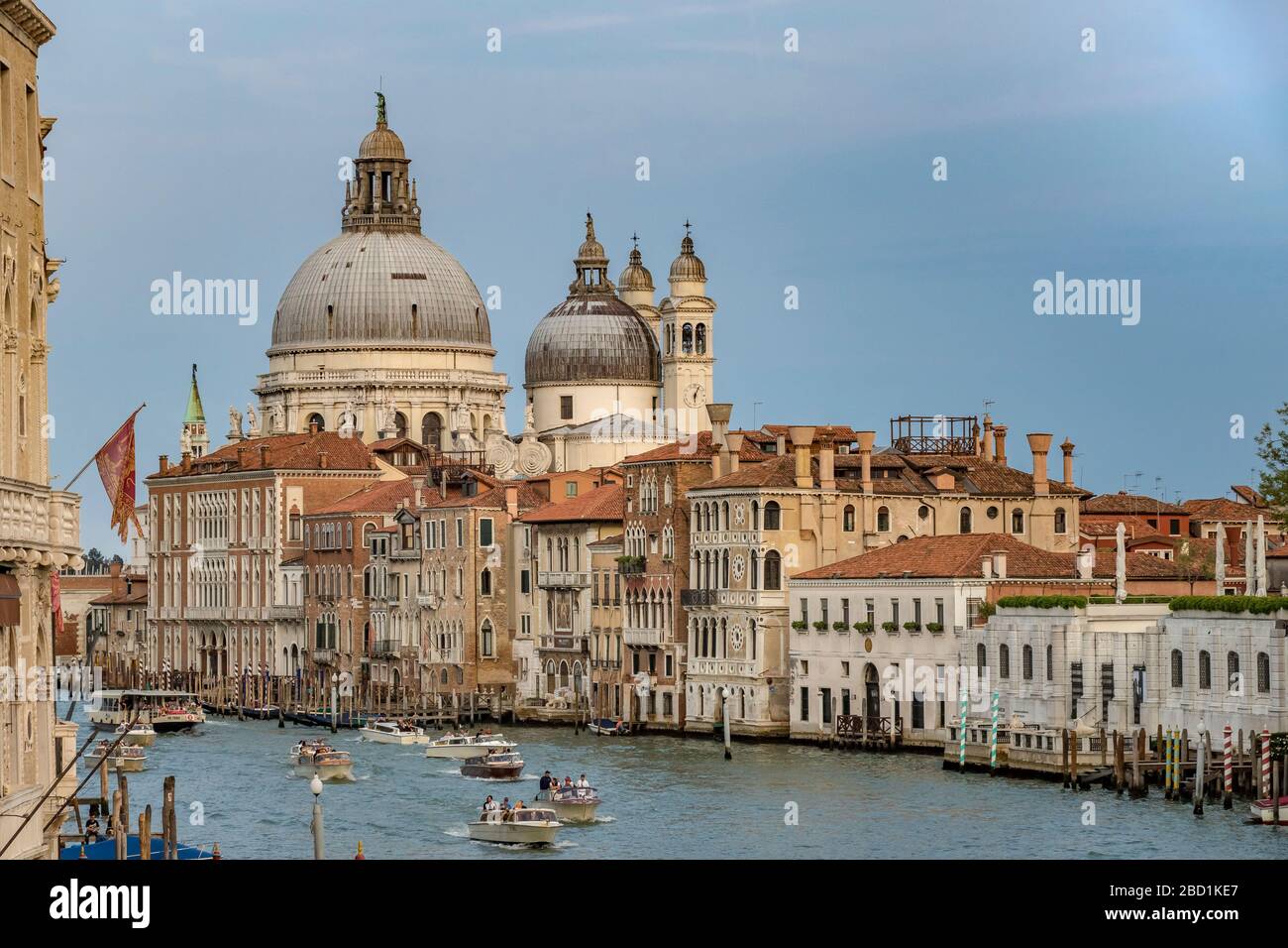 Des bateaux-taxis et un vaporetto naviguant le long du Grand Canal avec la basilique Santa Maria della Salute en arrière-plan, Venise, Italie Banque D'Images