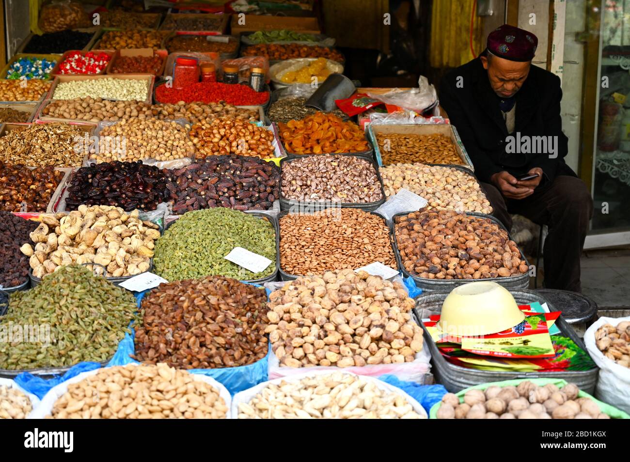 Uyghur, un grand détenteur musulman qui vend des fruits et des noix cultivés localement et séchés, Kashgar, Xinjiang, Chine, Asie Banque D'Images