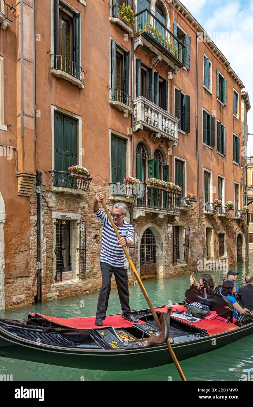 Un gondolier qui dirige sa télécabine avec son oar le long de Rio de San Moise, un canal à Venise, Italie Banque D'Images