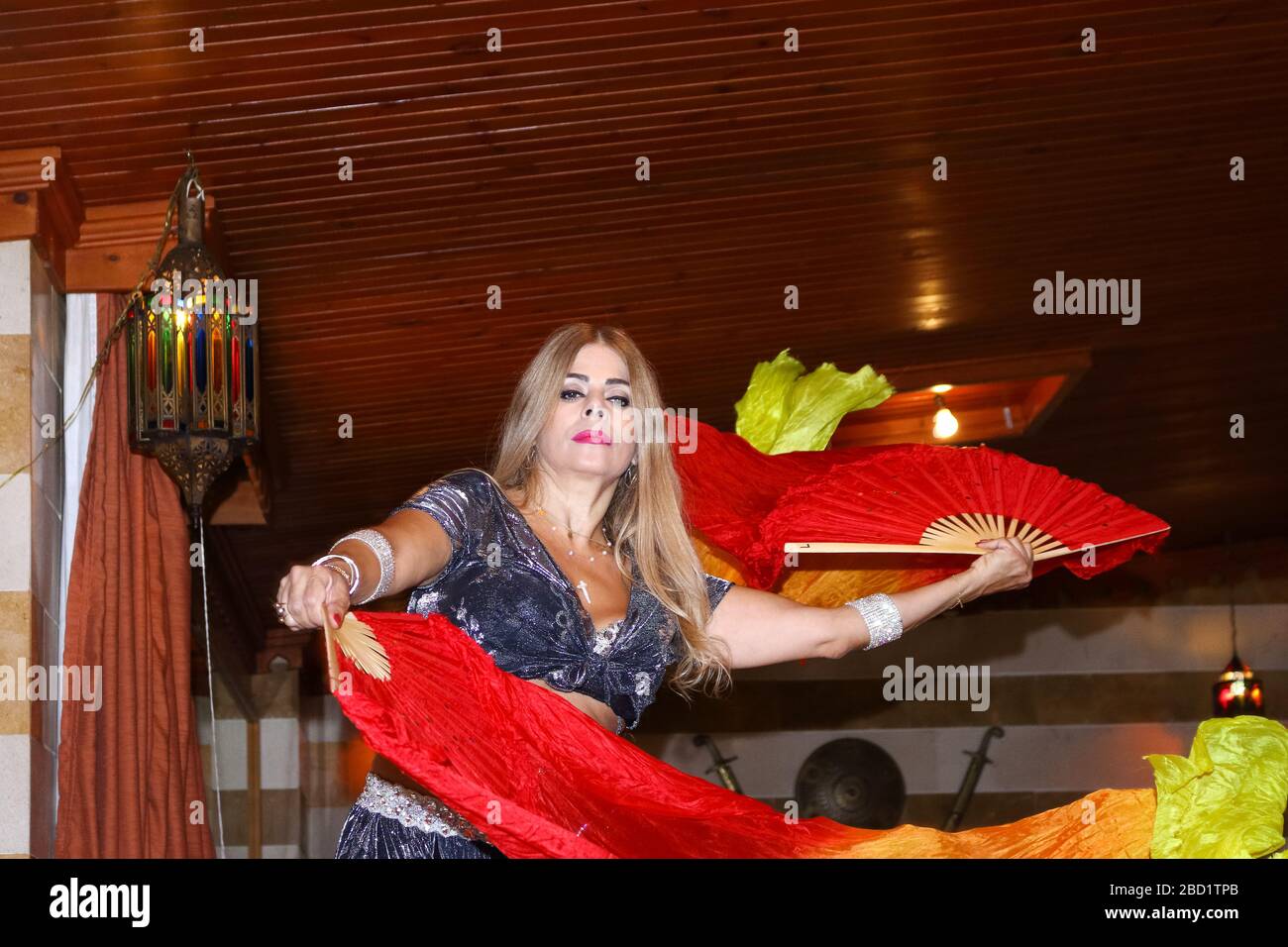 Beyrouth, Liban - 30 mai 2017 : femme mûre gracieuse d'origine libanaise, qui danse du ventre traditionnelle à l'aide d'un voile coloré à l'intérieur. Banque D'Images
