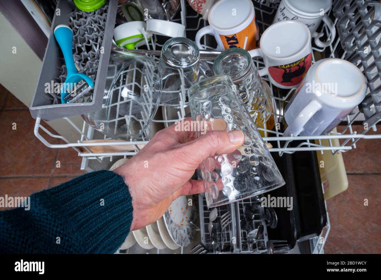 Une main d'homme met un verre sale dans un lave-vaisselle Photo Stock -  Alamy