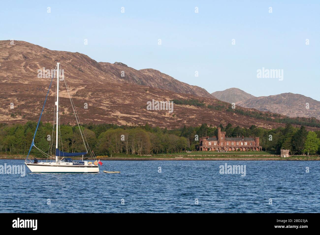 Yacht à voile ancré dans le Loch Scresort et le château de Kinloch, l'île de Rum, Hebrides, Ecosse Banque D'Images