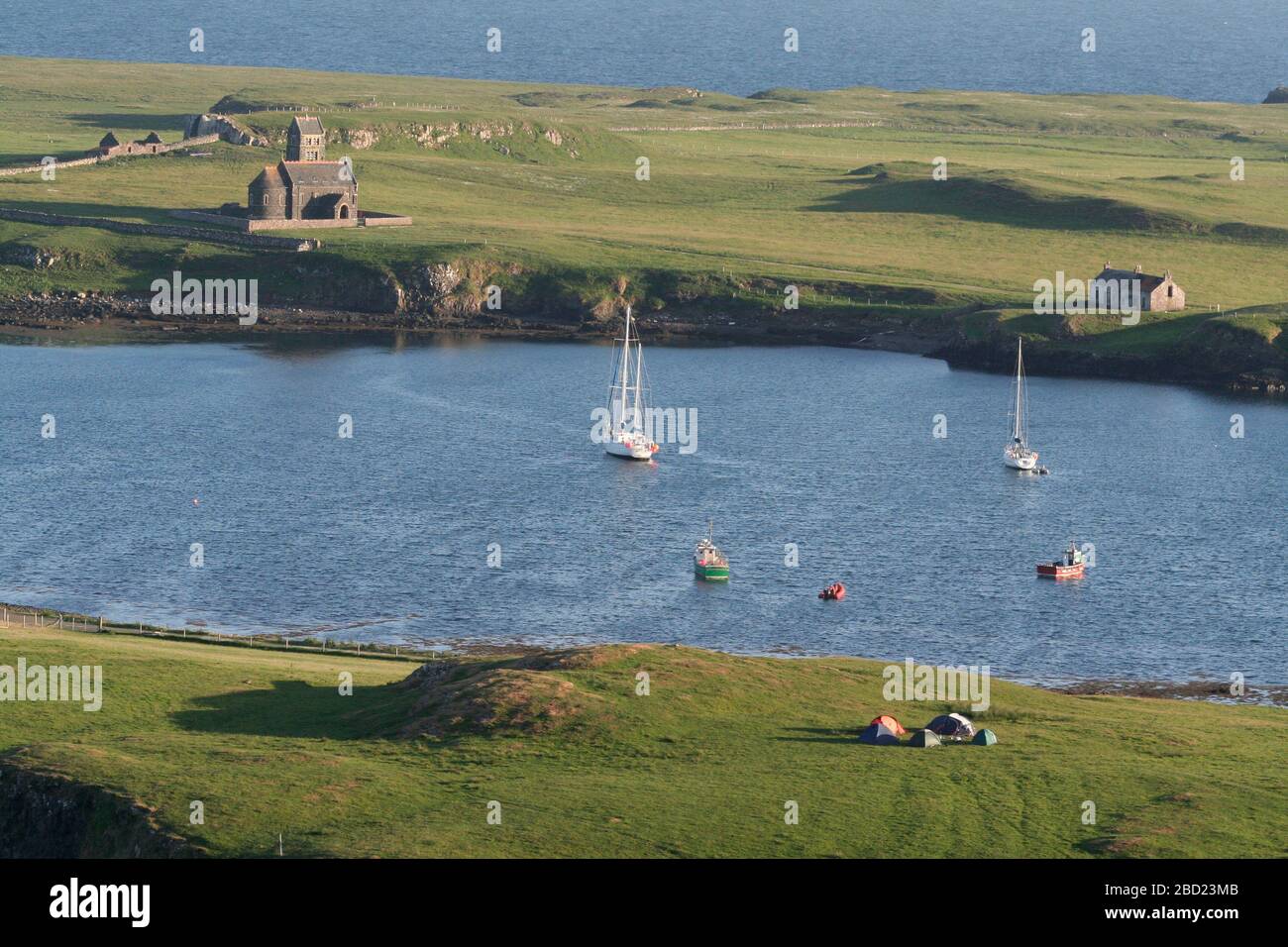 Yachts à voile et bateaux de pêche dans le port de Canna, en face de l'église sur Sangay de Canna, Hebrides, Ecosse Banque D'Images