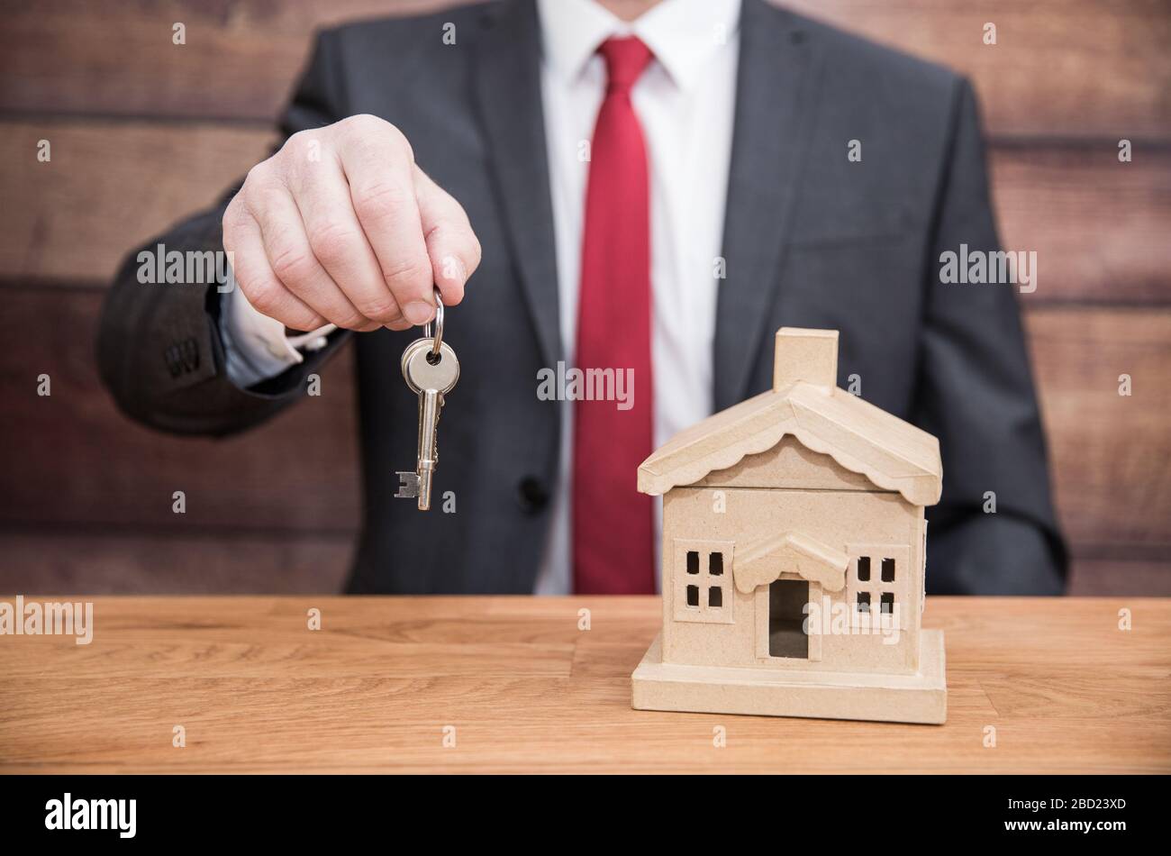 Un concept d'un homme d'affaires tel qu'un fournisseur d'hypothèques ou un agent immobilier qui remet les clés d'une maison ou d'une maison à de nouveaux propriétaires Banque D'Images Un concept d'un homme d'affaires tel qu'un fournisseur d'hypothèques ou un agent immobilier qui remet les clés d'une maison ou d'une maison à de nouveaux propriétaires Banque D'Images