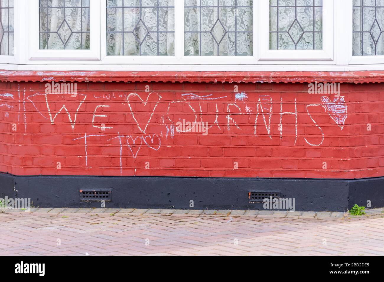 Nous aimons notre NHS craqué sur le mur de la maison pendant la période de verrouillage de la pandémie de Coronavirus COVID-19. Message d'appréciation Banque D'Images