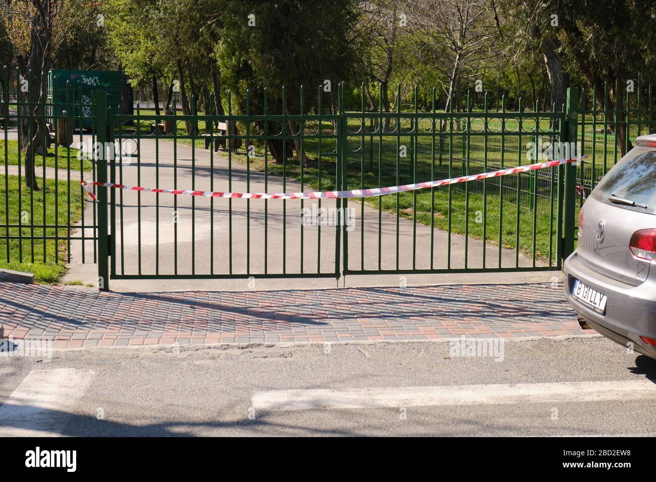 Bucarest, Roumanie - 6 avril 2020: L'entrée du parc a fermé avec un ruban barricade rouge et blanc, pendant que le gouvernement a imposé des mesures de distanciation sociale but Banque D'Images