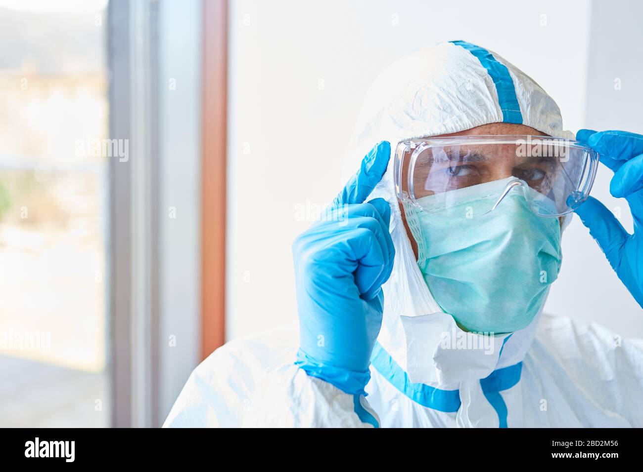 Médecin en clinique avec des vêtements de protection et des lunettes de protection et un masque facial pour l'épidémie de coronavirus Banque D'Images