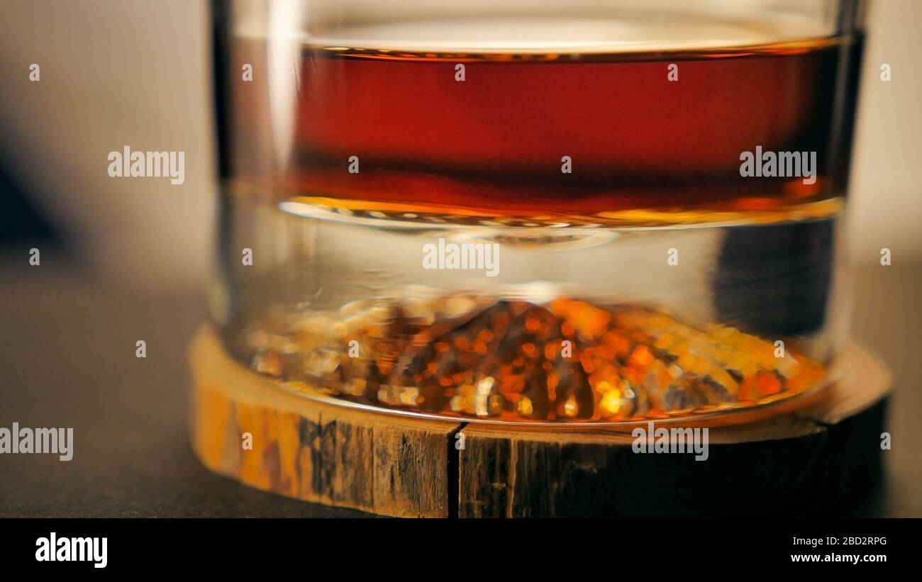 Un verre de rhum de luxe sur un dessous de verre en bois Photo Stock - Alamy