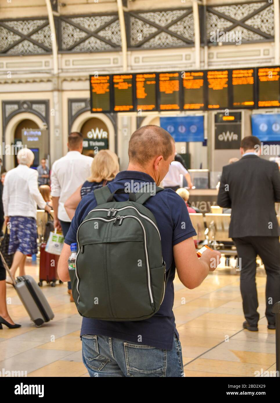 LONDRES, ANGLETERRE - JUILLET 2018: Voyageur ferroviaire sur le parcours de la gare de Paddington de Londres vérifiant leur billet contre le départ Banque D'Images