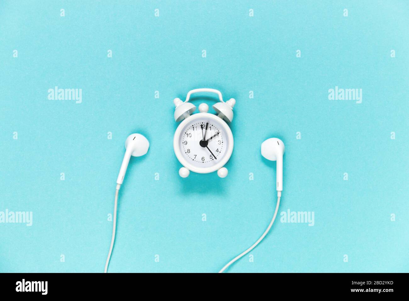 Casque et réveil sur fond bleu. Concept musical. Vue de dessus avec espace de copie. Banque D'Images