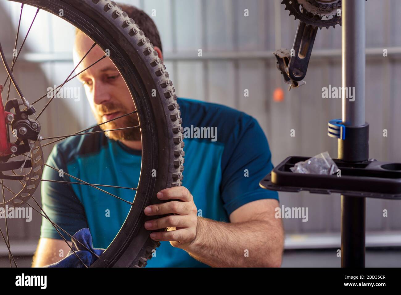 Mécanicien dans un atelier de réparation de bicyclettes de huiler la chaîne d'un vélo. L'homme maintenant sa bicyclette pour la nouvelle saison de conduite. Processus de travail. Banque D'Images