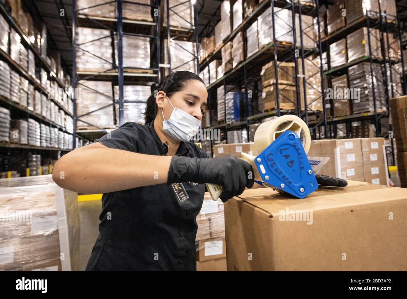 McLane Global Employees emballe des boîtes alimentaires pour les élèves des écoles rurales fermées en raison de la pandémie COVID-19 le 26 mars 2020 à Houston, Texas. McLane Global, en collaboration avec le département américain de l'agriculture, PepsiCo et Baylor Collaborative, fournissent près de 1 000 000 de repas par semaine aux étudiants dans le besoin. Banque D'Images