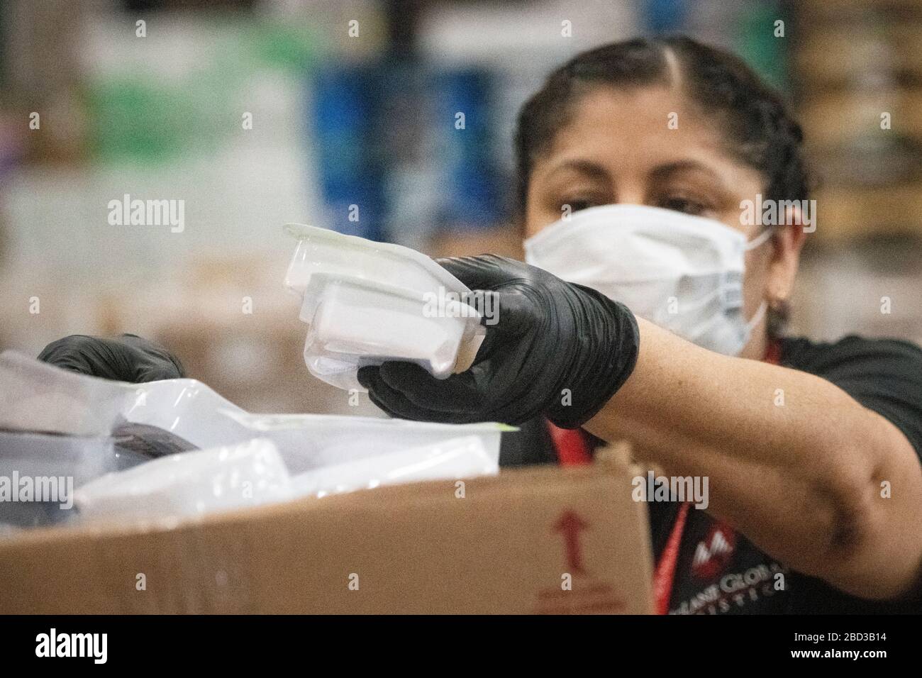 McLane Global Employees emballe des boîtes alimentaires pour les élèves des écoles rurales fermées en raison de la pandémie COVID-19 le 26 mars 2020 à Houston, Texas. McLane Global, en collaboration avec le département américain de l'agriculture, PepsiCo et Baylor Collaborative, fournissent près de 1 000 000 de repas par semaine aux étudiants dans le besoin. Banque D'Images