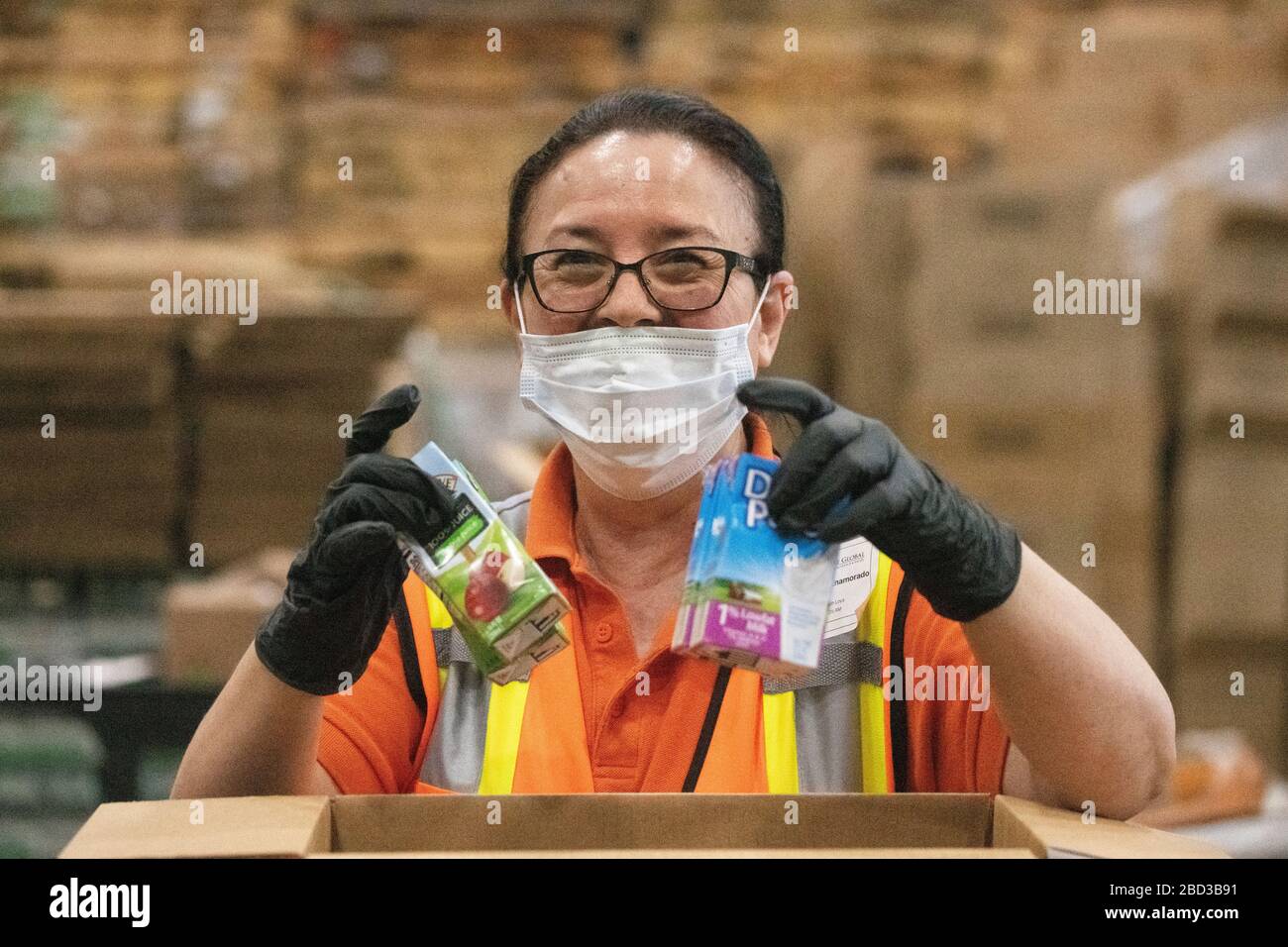 McLane Global Employees emballe des boîtes alimentaires pour les élèves des écoles rurales fermées en raison de la pandémie COVID-19 le 26 mars 2020 à Houston, Texas. McLane Global, en collaboration avec le département américain de l'agriculture, PepsiCo et Baylor Collaborative, fournissent près de 1 000 000 de repas par semaine aux étudiants dans le besoin. Banque D'Images