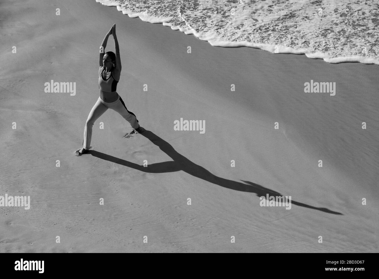 Femme pratique le yoga sur la plage au parc national de Makena, Maui, Hawaï. Banque D'Images