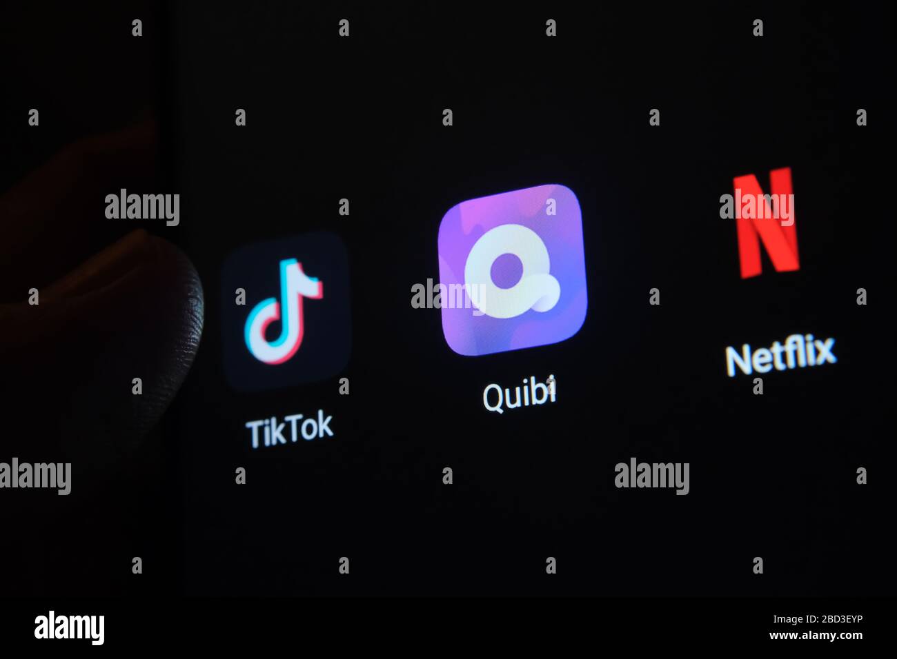 Stone / Royaume-Uni - 6 avril 2020: Quibi app sur un écran de smartphone et le lancement de doigt. Quibi est une application vidéo similaire à TikTok et Netflix Banque D'Images