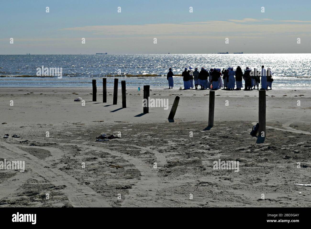 Des femmes noires et un prêtre prient sur la plage de Galveston, Texas Banque D'Images