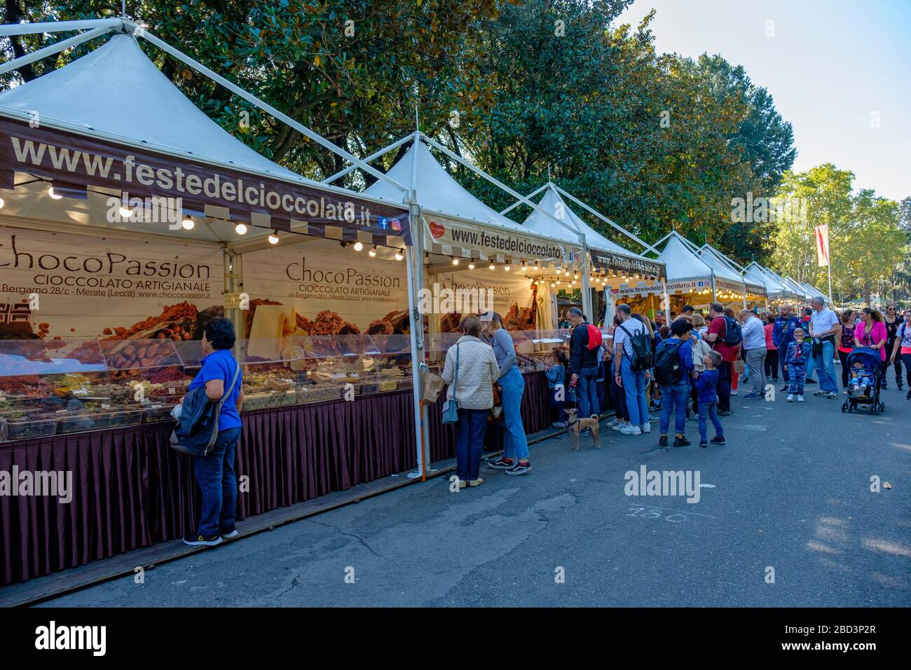 Les gens qui achètent du chocolat dans des stands à une foire au chocolat au parc de la Villa Borghese, Rome, Italie. Banque D'Images