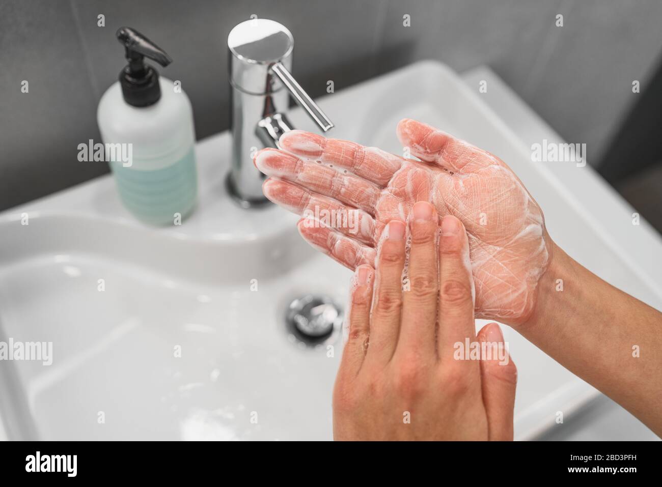 Lavage des mains le savon de frottement dans les mains qui moussant les bulles de mousse pour la prévention du virus Corona COVID-19, l'hygiène pour arrêter la propagation du coronavirus. Femme étape de lavage des mains à l'évier de salle de bains. Banque D'Images