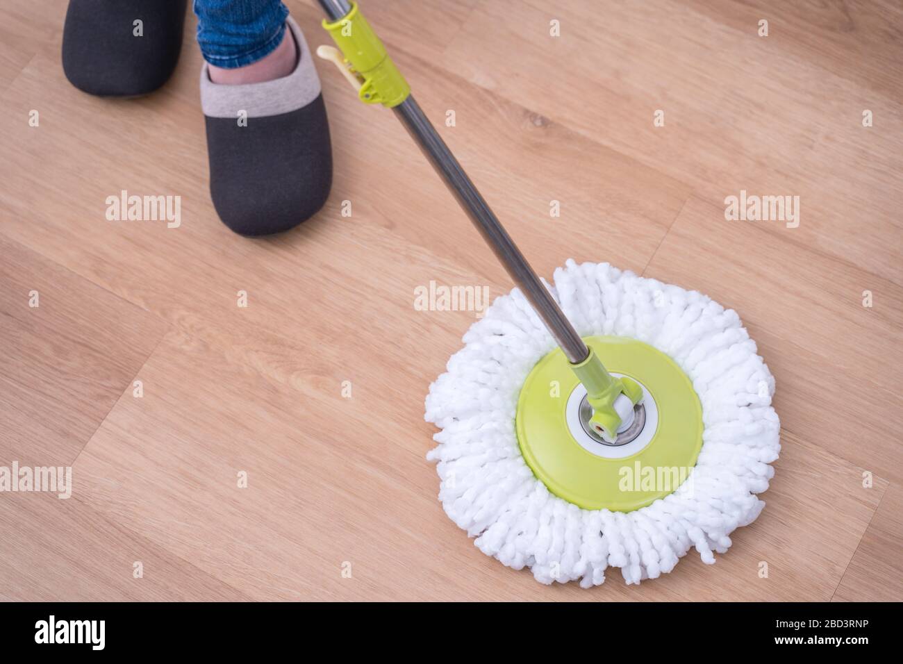 Planchers de balai à franges. Jeune femme laver le sol en bois à la maison  avec un balai à franges, des produits de nettoyage, concept  d'antibactérien, prévention des virus, gros plan Photo