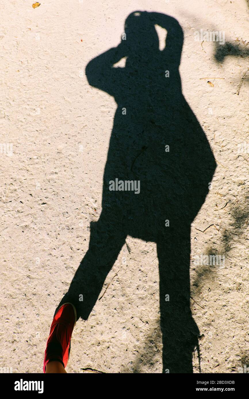Incroyable photographe féminin selfie matin, ombre drôle de jean déchiré, les chaussures rouges de personnes debout faire impression concept par ombre, silhouette Banque D'Images