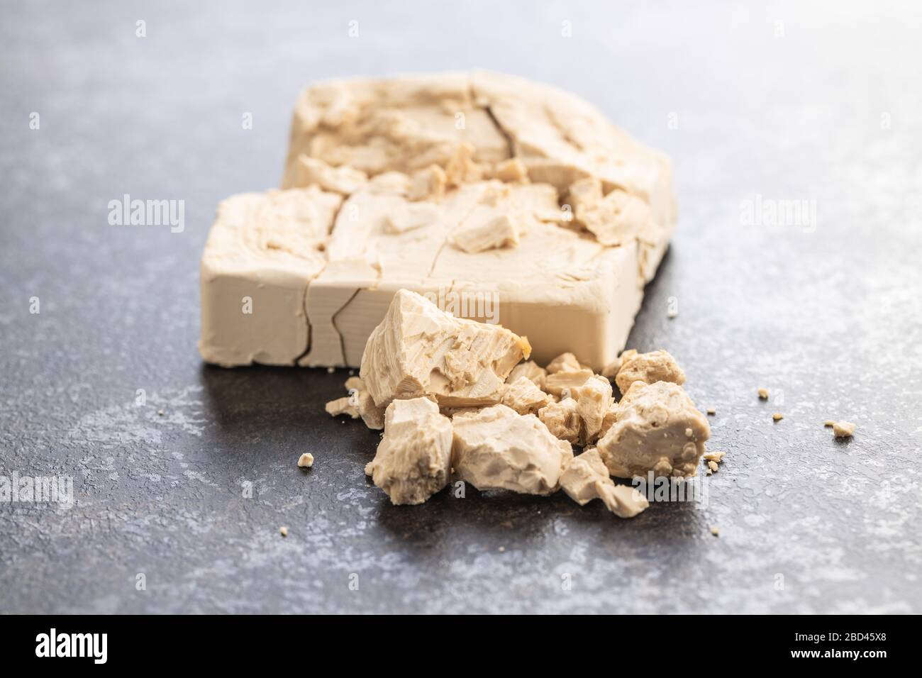 Blocs de levure frais sur table de cuisine noire. Banque D'Images