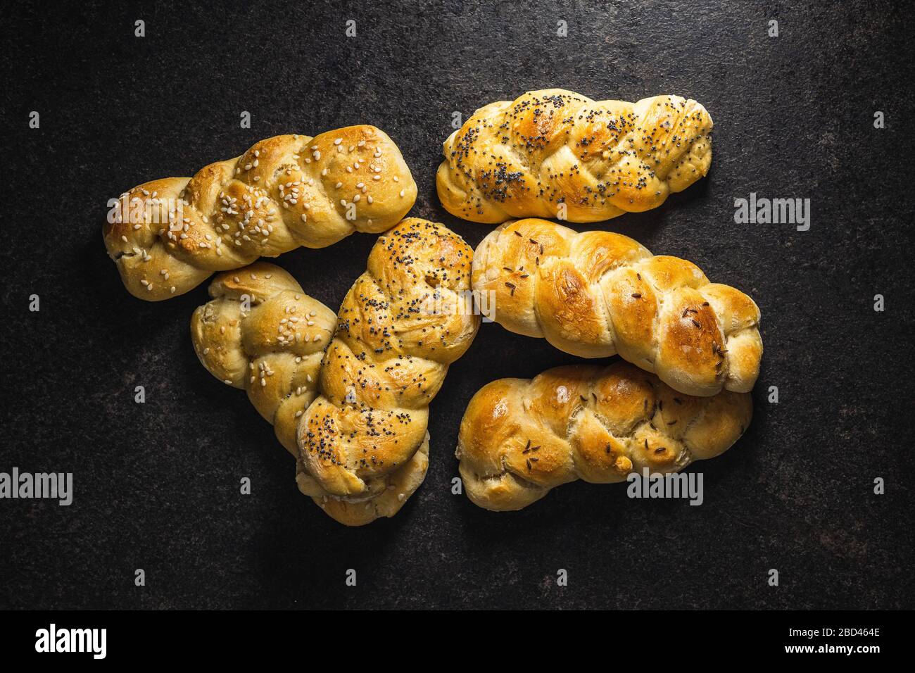 Délicieux petits pains tressés sur une table de cuisine noire. Vue de dessus. Banque D'Images
