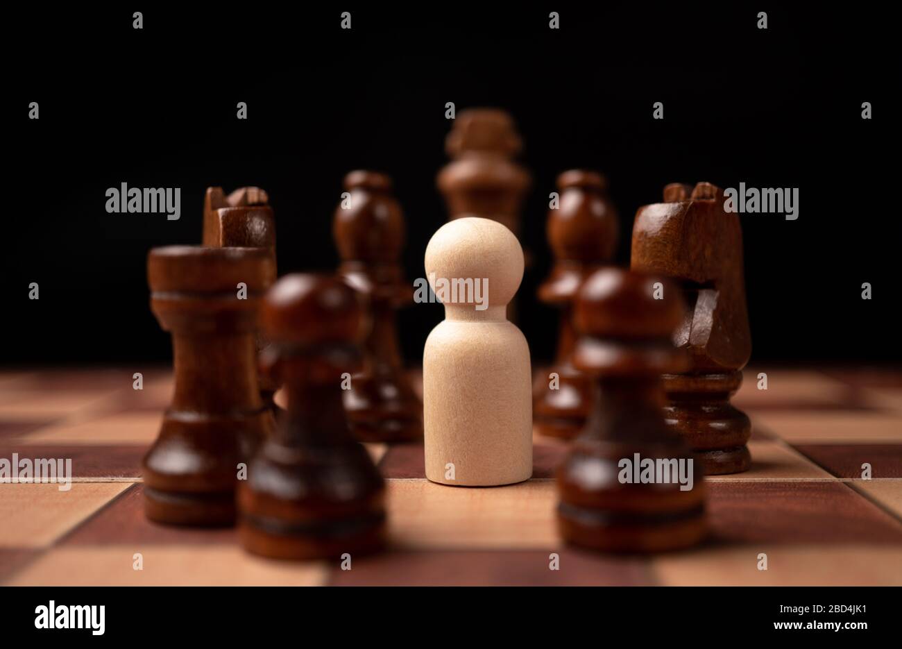 Les personnages en bois (homme d'affaires) qui se tiennent face au roi des échecs et qui sont dans le cercle des échecs. Les nouveaux acteurs commerciaux sont confrontés à des défis. La direction Banque D'Images