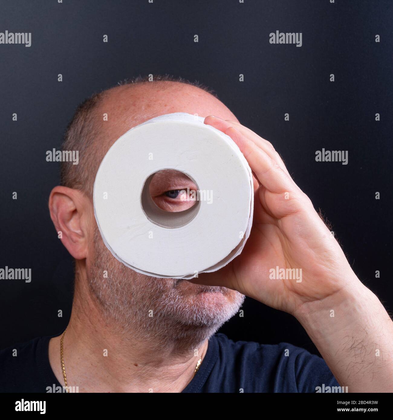 un homme regarde à travers un rouleau de papier toilette Banque D'Images un homme regarde à travers un rouleau de papier toilette Banque D'Images