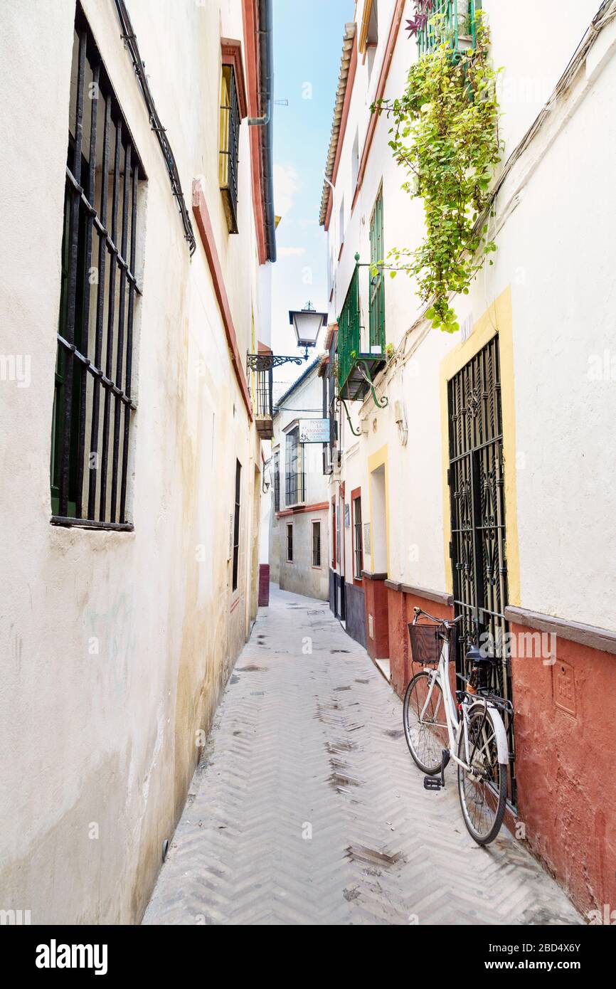 Vélo stationné dans une rue étroite à Séville, Andalousie, Espagne Banque D'Images