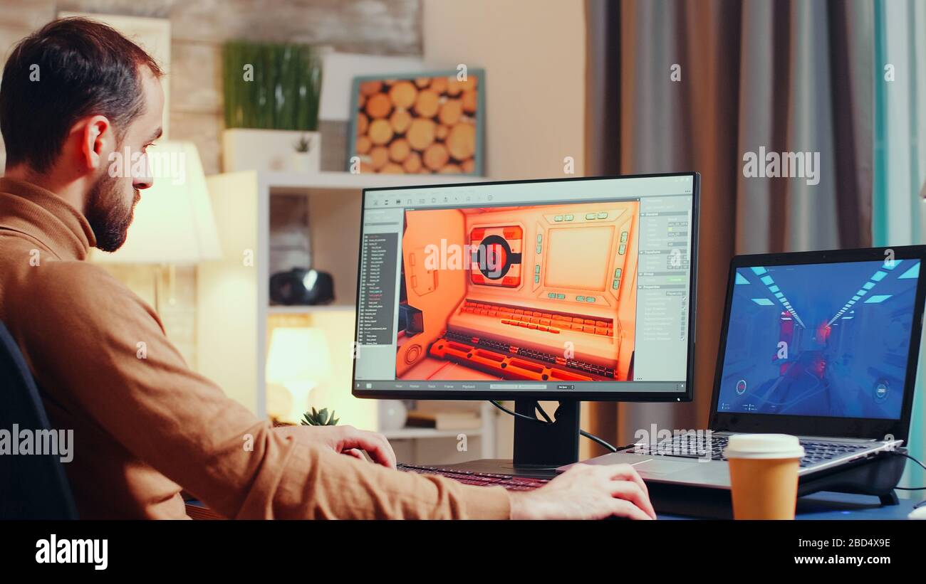 Jeune développeur de jeux utilisant un logiciel moderne pour concevoir l'interface. Banque D'Images