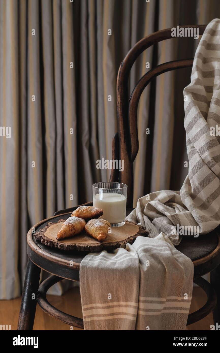 Croissants et lait servis sur une ancienne chaise dans la chambre Banque D'Images