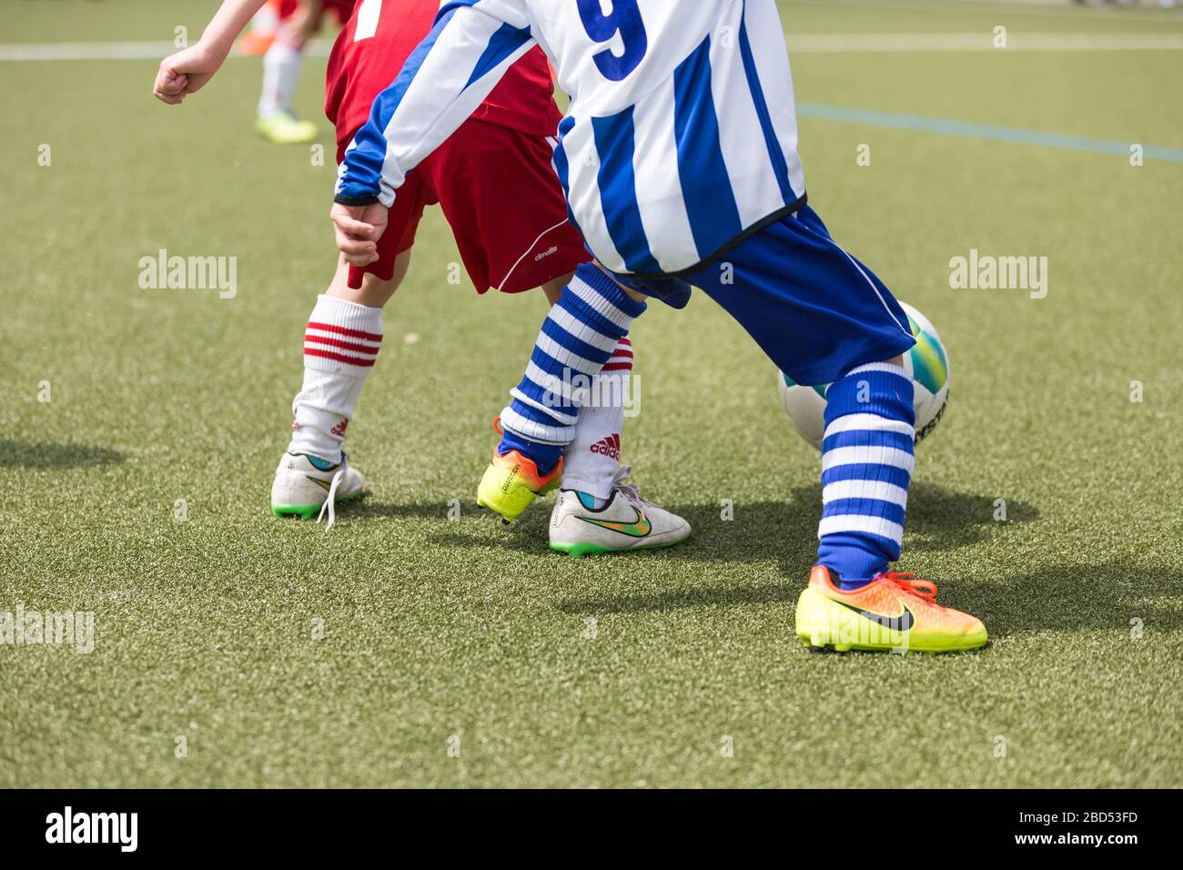 les garçons jouant au football sur gazon artificiel Banque D'Images