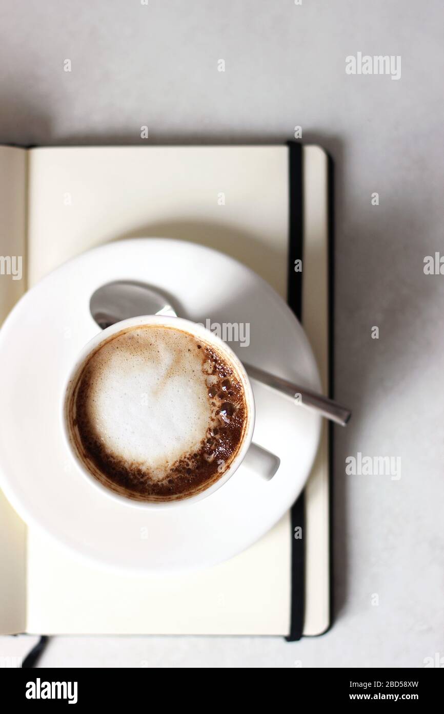 Tasse de café sur livre blanc ouvert. Travail à partir de la maison. Banque D'Images